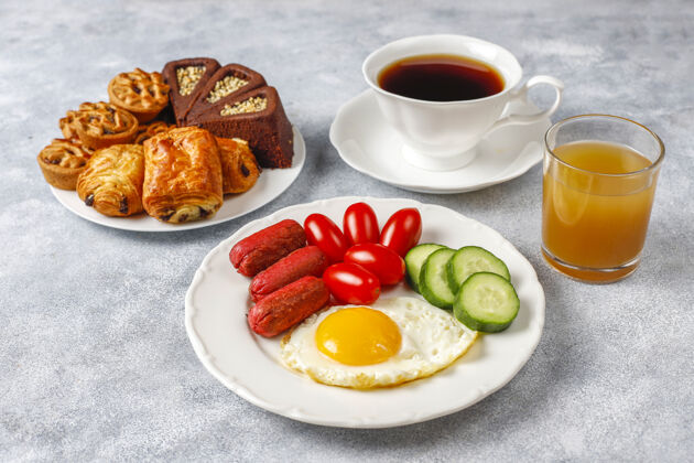 饮食早餐盘子里有鸡尾酒香肠 煎蛋 樱桃番茄 糖果 水果和一杯桃子汁营养咖啡膳食