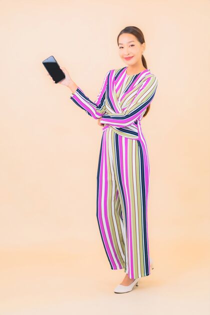 互联网肖像美丽的亚洲年轻女子用智能手机上色电话韩语站立