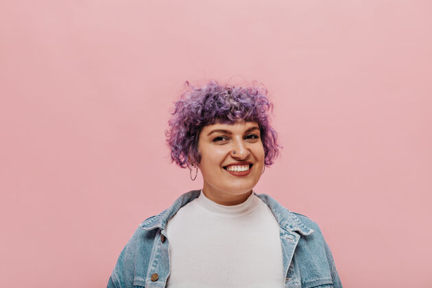 肖像酷酷女人的肖像 卷曲的紫色短发 带着刺眼的微笑 孤立的粉色信息女性女人