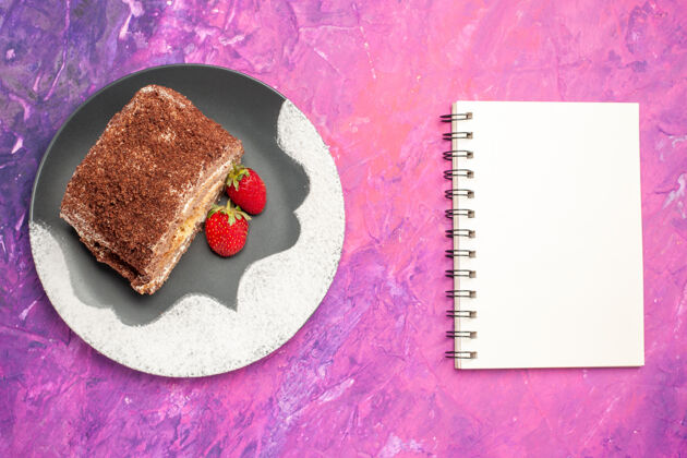 美味粉红色表面上有草莓的美味甜面包卷俯视图美味糖果饼干