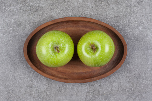 自然两个新鲜的绿色苹果放在厨房的木板上小吃食物美味