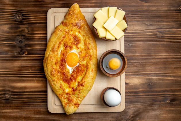 烘焙顶视图新鲜烤面包配煮熟的鸡蛋放在棕色木制桌子上面包面团餐包早餐鸡蛋晚餐桌子鸡蛋