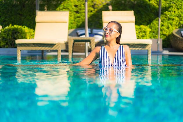 游泳肖像美丽的年轻女子放松微笑休闲度假酒店游泳池周围阳光酒店海滩