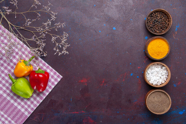 颜色顶视图彩色甜椒与不同的调味品对灰色背景的蔬菜辣椒辣味食物蔬菜甜椒胡椒