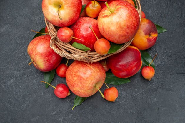 美味侧面特写查看水果红黄色水果和浆果与树叶在木篮篮子浆果壁板