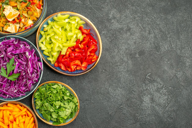 不同的蔬菜切片顶视图不同的蔬菜切片与鸡肉沙拉在黑暗的餐桌上健康沙拉饮食盘子健康菜肴