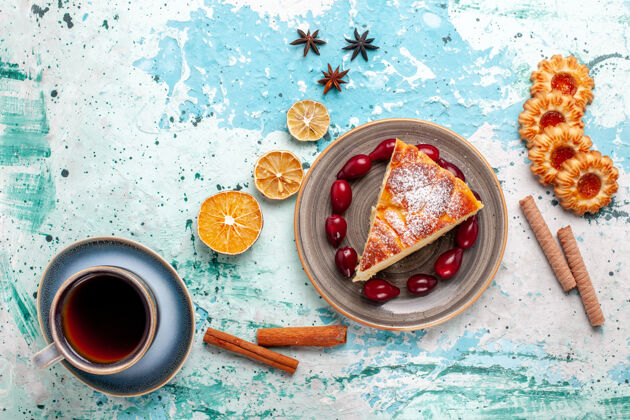 杯子顶视图蛋糕片上放着饼干和一杯茶 表面呈蓝色 水果蛋糕烤馅饼 饼干甜茶碟生的茶