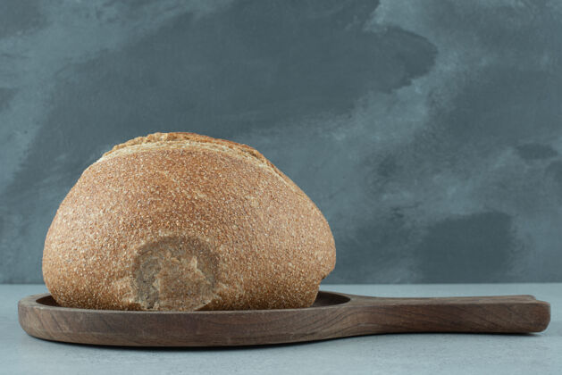 面包皮木板上的黑麦面包卷营养石头食品