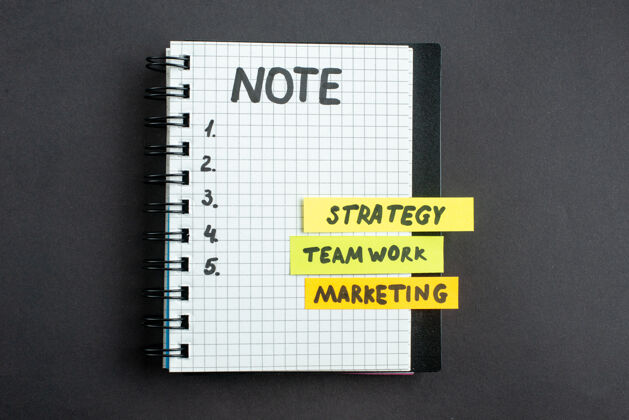 笔记本顶视图激励商业笔记带记事本在黑暗背景下商业成功工作领导办公室工作营销策略战略笔记工作