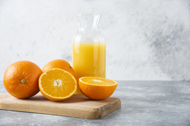 甜点在木板上放一个装有橙子切片的果汁的玻璃罐成熟明亮多汁