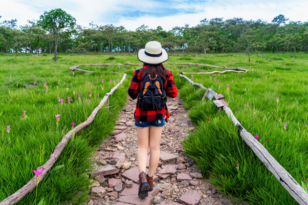 探索背着背包在泰国克拉丘花坛散步的女游客旅游理念野外徒步旅行山峰