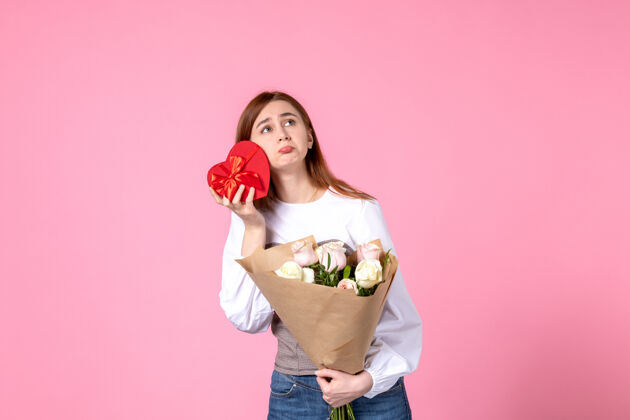 花正面图：年轻女性 带鲜花 在粉色背景上作为妇女节礼物 横向三月平等 女性玫瑰色 女性爱感性玫瑰年轻女性礼物