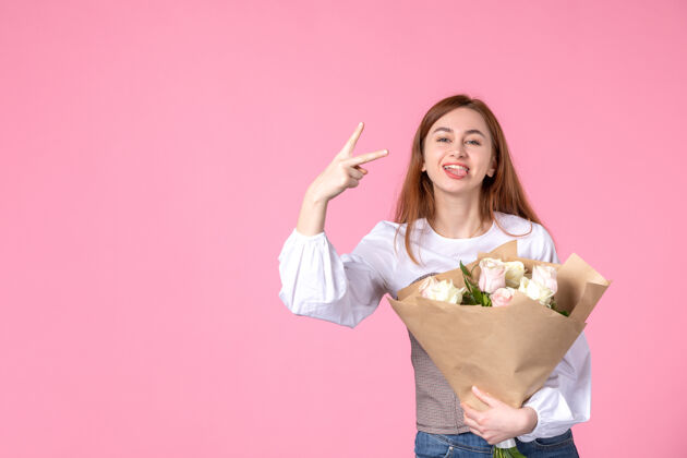 花束正面图：带花朵的年轻女性 作为女性节礼物 粉色背景 横向女性化 三月女性约会平等 爱感性玫瑰人花