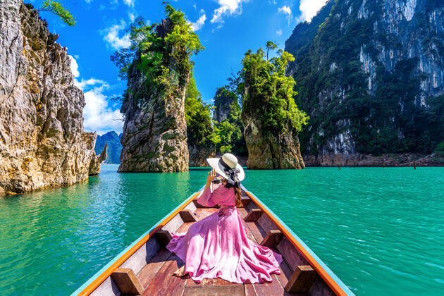 河流泰国素拉特萨尼省考索国家公园 美丽的女孩坐在船上看着ratchaprapha大坝的群山景色泻湖水