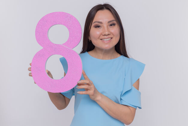 制造快乐而积极的亚洲女人拿着纸板做的8号 站在白色的墙上 面带微笑 兴高采烈地庆祝国际妇女节欢呼积极硬纸板