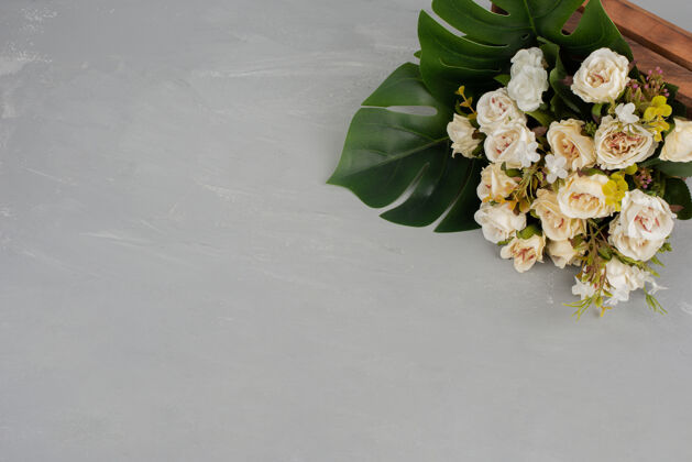 顶视图美丽的白玫瑰花束在灰色的表面玫瑰开花花卉