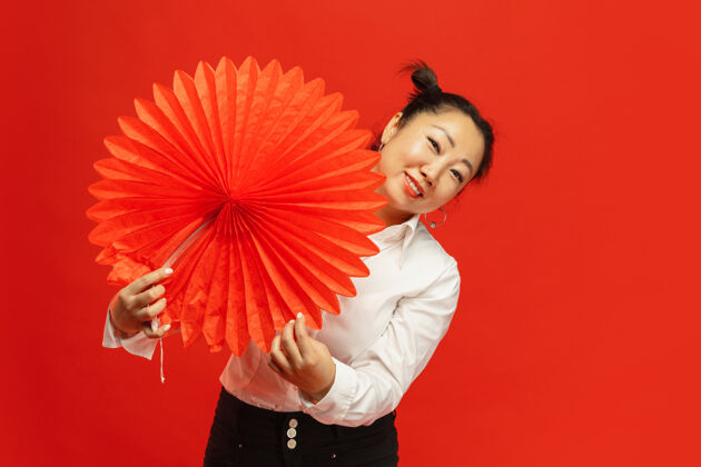中国亚洲年轻女子手持红墙大灯传统节日服装