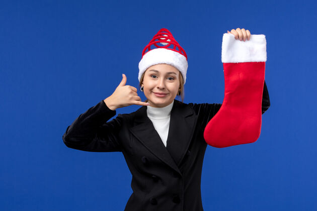 欢呼正面图年轻的女性拿着圣诞袜在蓝色的墙上过年工人看法举行
