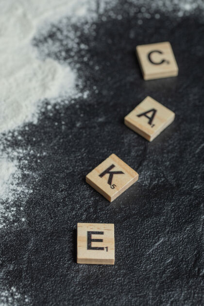 文字木制字母拼写像蛋糕上的黑色蛋糕字母人物