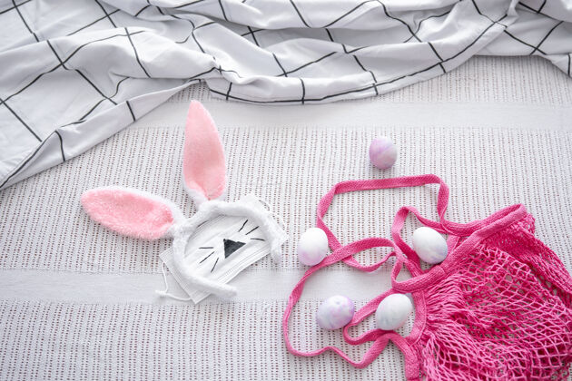 面具复活节作文有一个粉红色的线袋 装饰复活节兔子耳朵 一个医用面具和鸡蛋检疫流行病传统