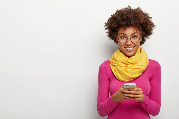 人乐观无忧无虑的黑皮肤年轻女子手持现代手机 发送信息 浏览网页现代非洲社会