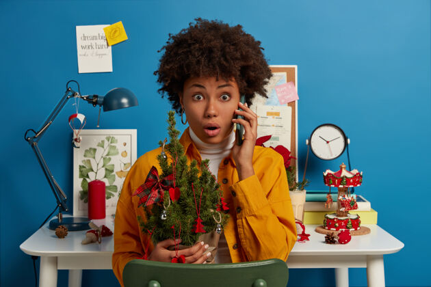 枞树惊恐万状的非洲发型女人 捧着漂亮的圣诞树 忘了买节日必备的东西呼叫夏娃衣服
