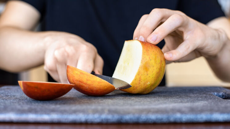 甜点一个男人用刀在烹饪板上切苹果水果秋天饮料