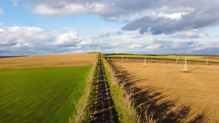 地平线无人机俯瞰摩尔多瓦的大自然 播种的田地 行驶的汽车 沿途的树木 多云的天空农作物环境全景