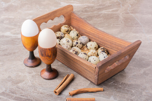 新鲜把鹌鹑蛋放在石头表面的木托盘里午餐传统厨房