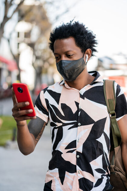 面具一幅非洲游客在街上户外散步时用手机的画像旅游户外男性