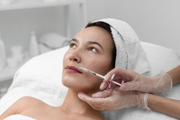 美容治疗美容师在给女性客户注射填充物美容护理注射美容治疗