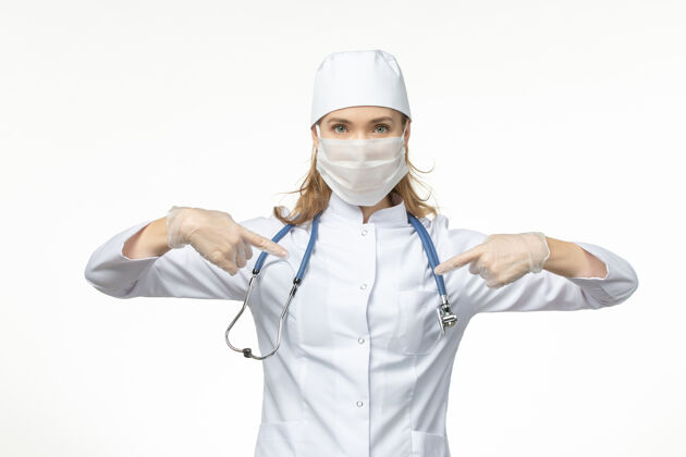 病毒前视图：女医生穿着医疗服 戴着口罩和手套 由于浅白色地板上有冠状病毒 大流行冠状病毒地板冠状病毒防护灯光