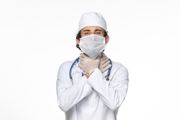 面具正面图：男医生穿着医疗服 戴着口罩 防止白墙病毒溅起冠状病毒大流行男性防护冠状病毒