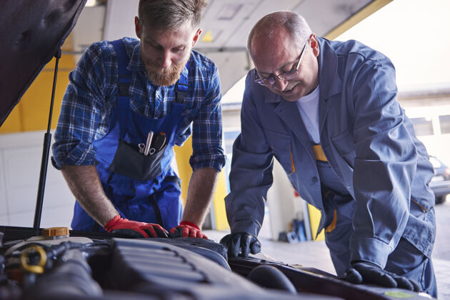 工作大众汽车车间的专业机械师修理伙伴关系汽车机械师