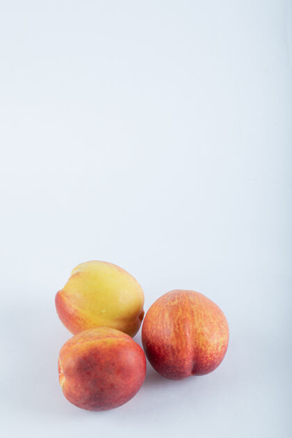 水果三个新鲜的油桃在白色上收获有机美味