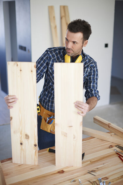 比较带木板的建筑工人工作测量退休