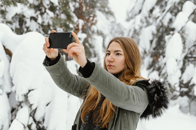 下雪冬日写真少女拍照电话下雪的冬天设备
