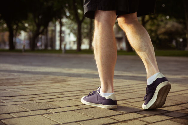 老年人在城市街道上担任跑步者的高级男子穿着运动鞋的腿部特写镜头音乐老年人养老金