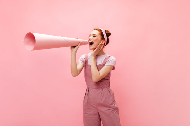 头发一个穿着粉红色衣服的女人 耳朵上贴着一张卷在管子里的大纸片红发时尚优雅