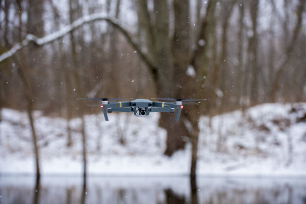 飞行在冬天飞行的黑色无人机相机飞行无人机