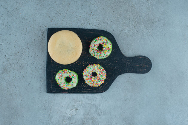甜点甜甜圈和饼干放在黑色大理石背景板上高质量照片填充糕点糖果