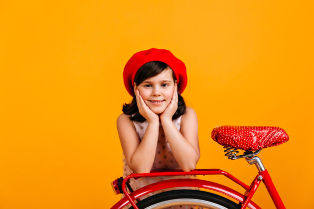 快乐戴着法国贝雷帽的可爱小女孩和自行车合影微笑的孩子被隔离在黄色休息骑夏天