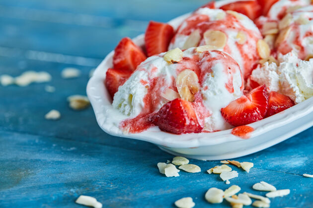 特写草莓香草冰淇淋 在白色盘子里撒上一点甜的香草草莓