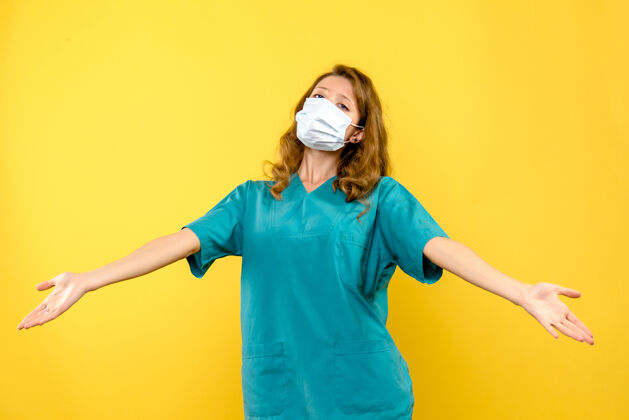 医疗黄色空间里戴着面具的年轻女医生的正面图一流行球衣