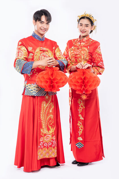 文化穿着旗袍的男女站在蜂巢灯下 隔离在白色背景上庆祝中国新年装饰