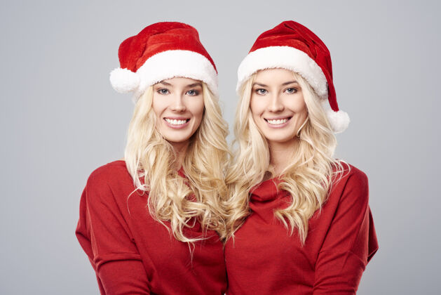 微笑戴圣诞帽的冬天双胞胎团结社区封闭