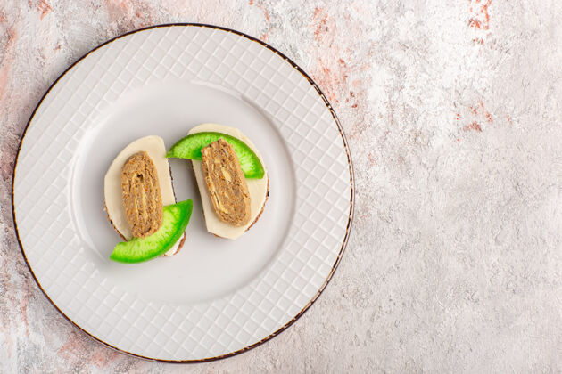 食物顶视图面包烤面包头和黄瓜片内板上的白墙肉蔬菜食品餐烤面包三明治切片盘子蔬菜