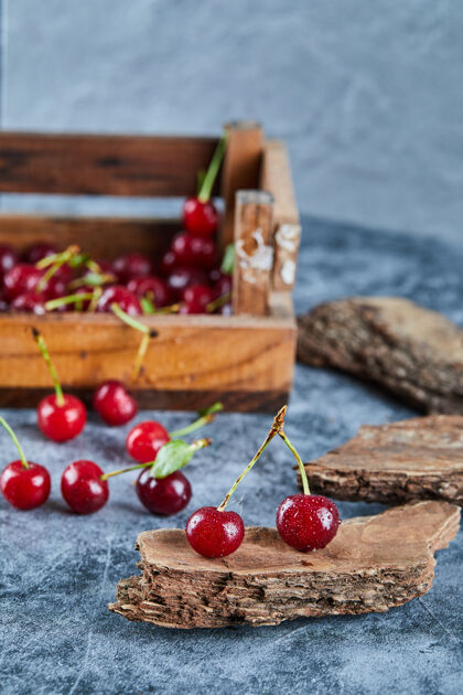 浆果红红的新鲜多汁的樱桃放在一个有叶子的木箱里美味新鲜篮子