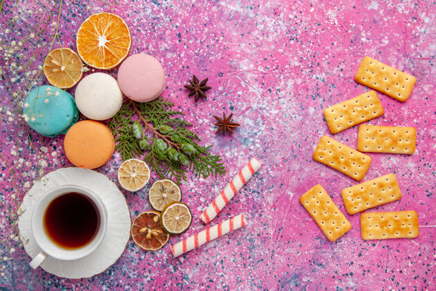 马卡龙顶视图一杯茶 配上五颜六色的法国马卡龙和饼干 粉红色的墙壁蛋糕饼干糖甜饼茶饼干装饰生的饼干