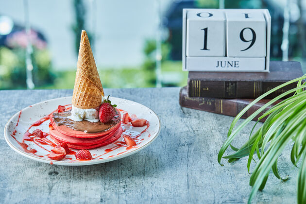 食物草莓煎饼 雪糕筒装在白色盘子里美味的甜食美味的